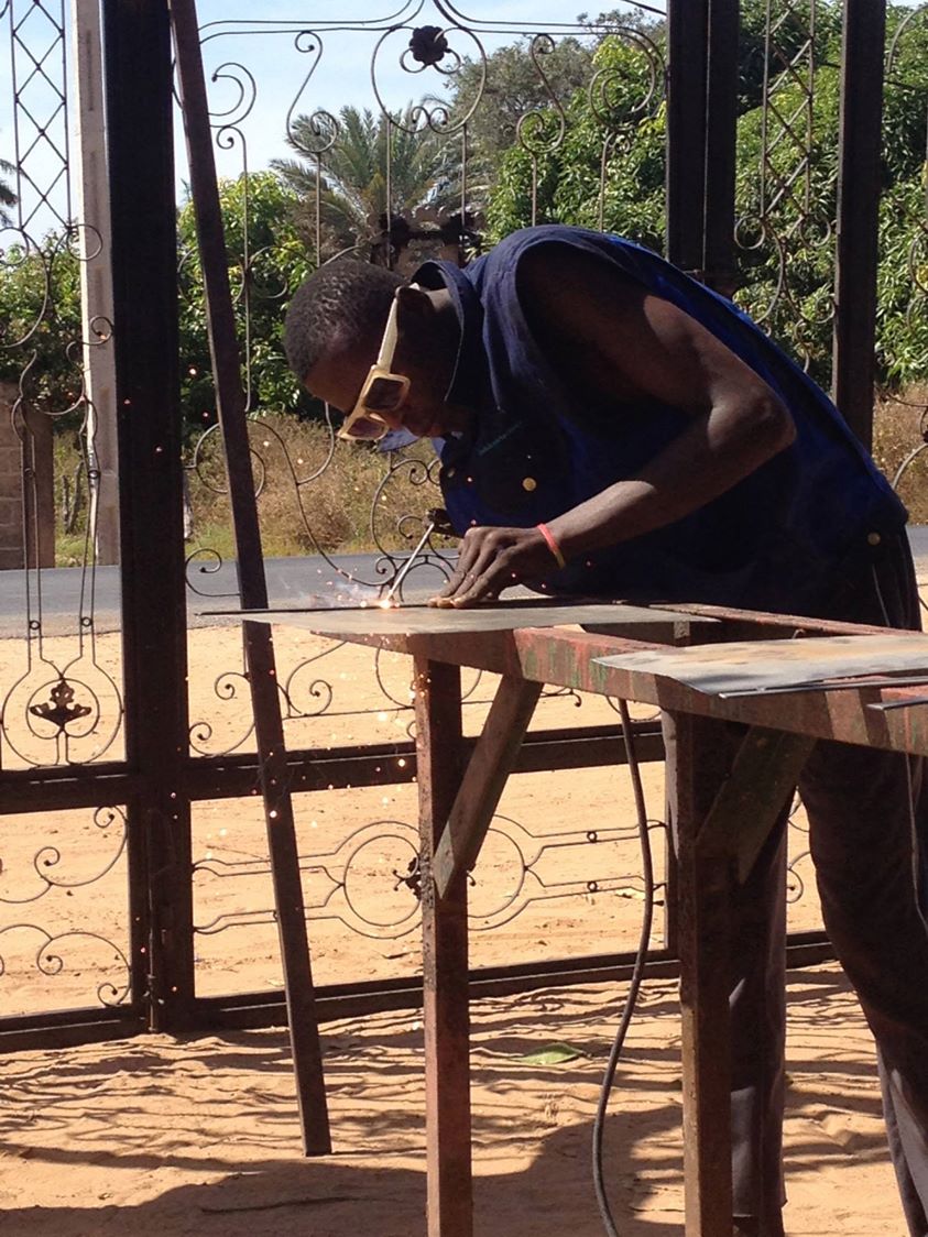 Sharing a communal meal on woven mats at night in The Gambia
